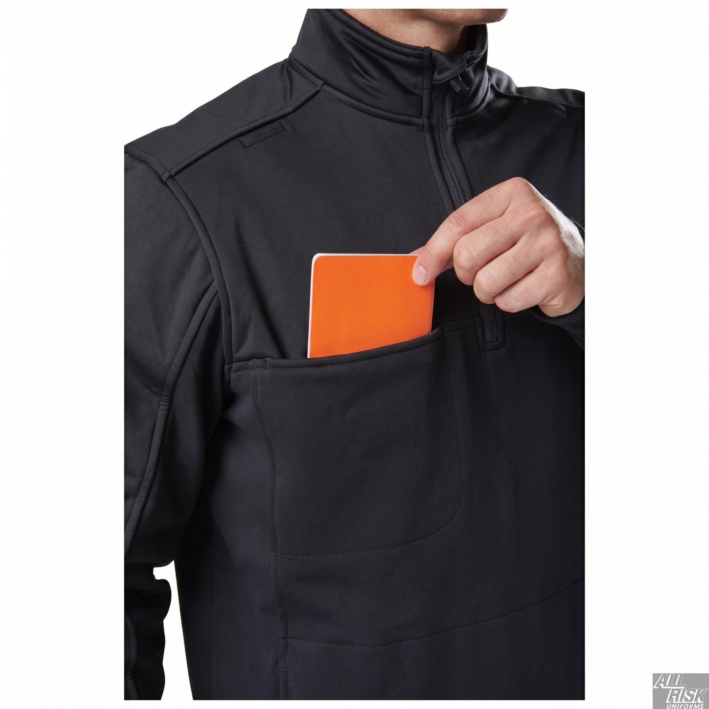 Model tucking an orange card into the hidden front chest pocket of the navy job shirt, demonstrating the concealed storage pocket.