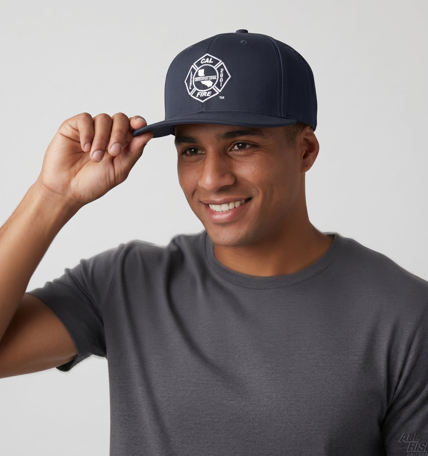 Smiling man tipping the brim of the navy Richardson PTS 20 snapback, the white CAL FIRE Local 2881 union shield on the crown, paired with a gray tee.