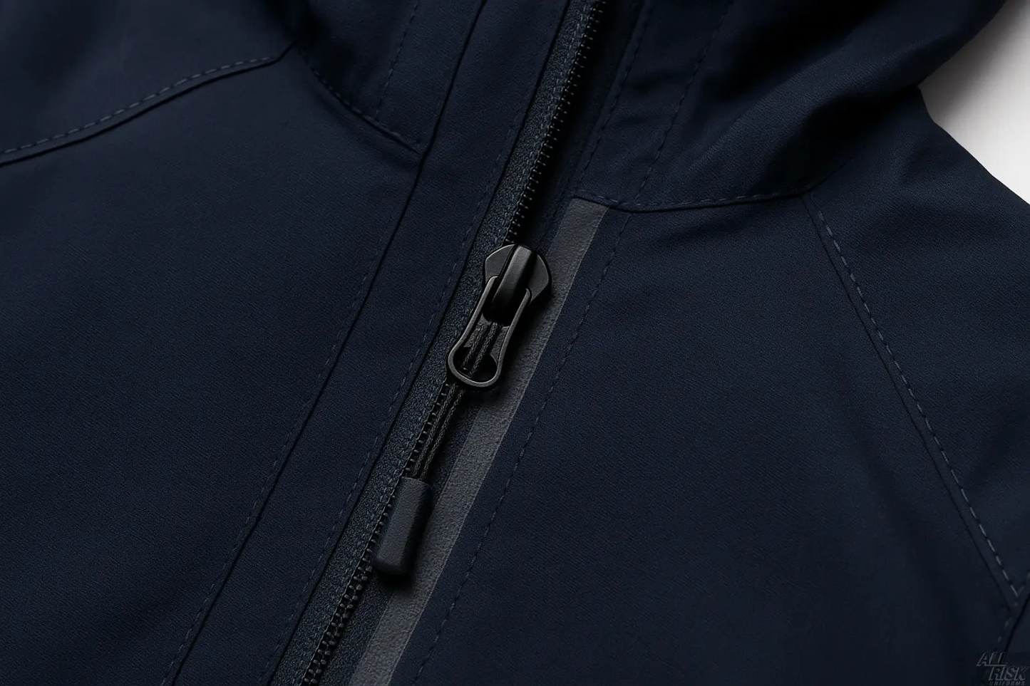 Close-up detail of the navy jacket's waterproof front zipper and pull tab.