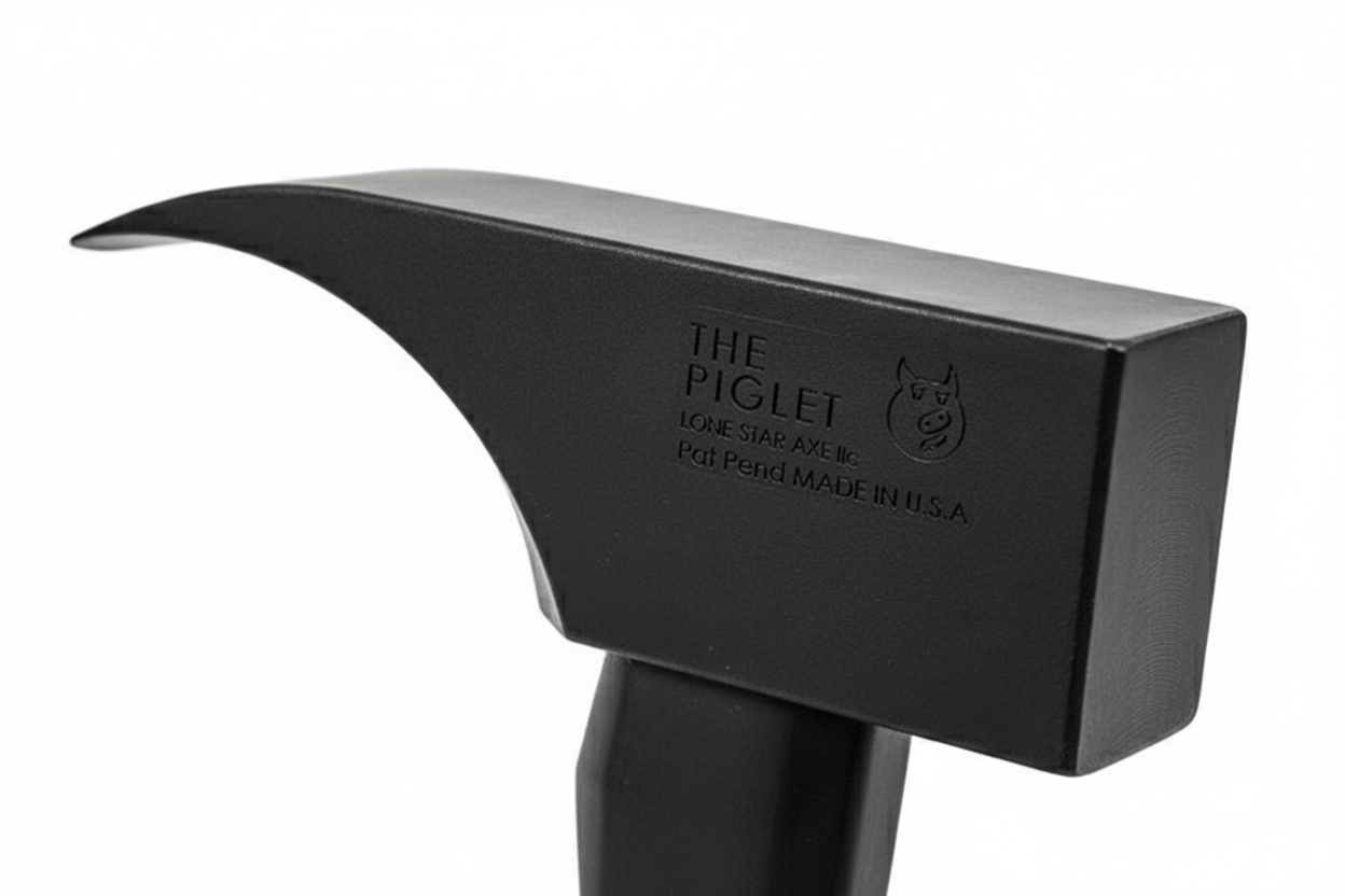 Close-up detail of PIGlet tool head showing 6lb tool steel construction with black oxide finish and striking surfaces
