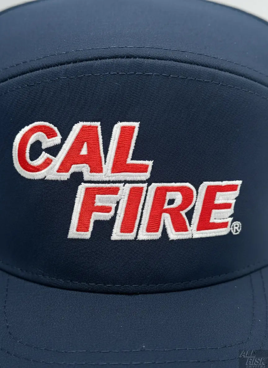 Close-up detail of 7 Panel Dome Athletic Hat in midnight navy showing red CAL FIRE text embroidery and performance fabric texture