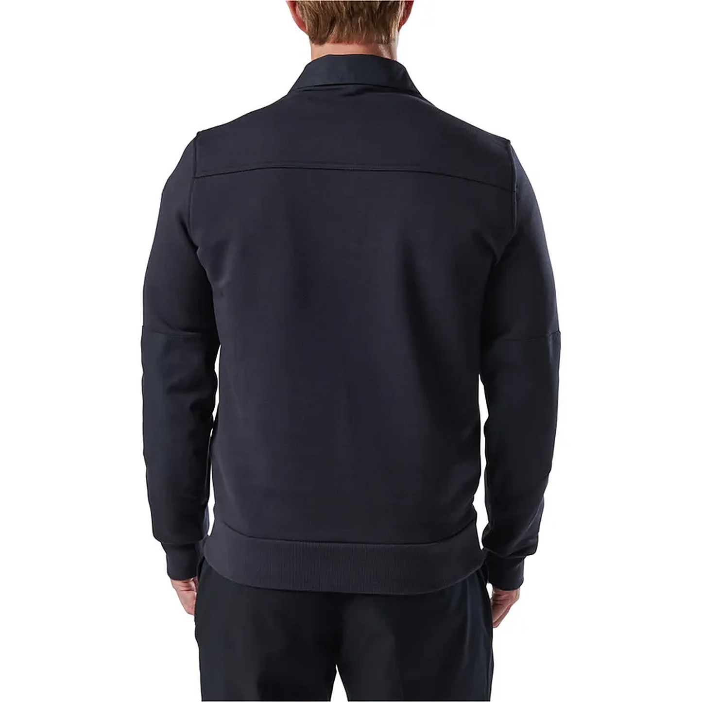 Back view of a model in the navy job shirt turned slightly to the left, showing the ribbed waist hem.