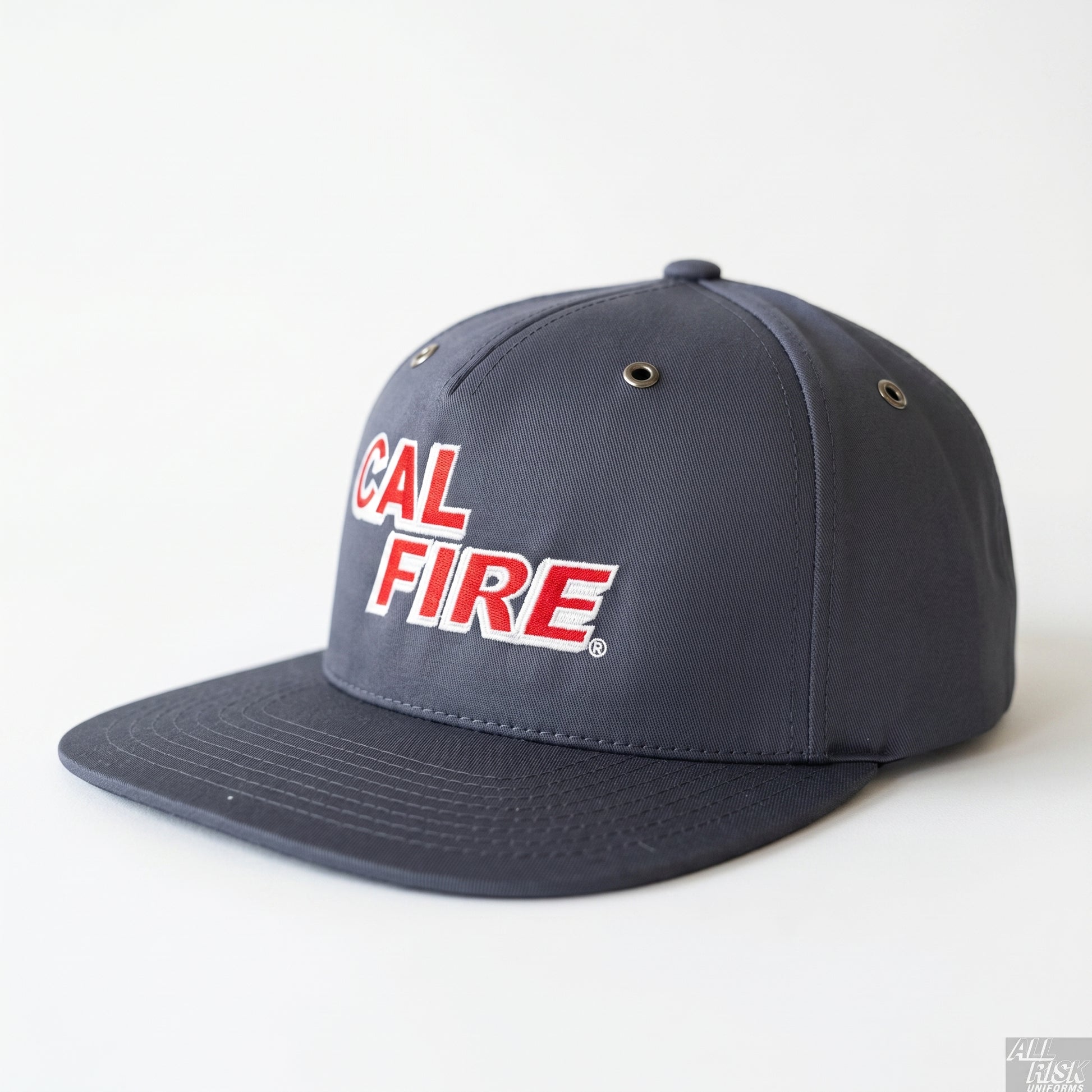 CAL FIRE Bucket Brigade flat-bill cap in charcoal-navy, front three-quarter view — red CAL FIRE block wordmark with white outline, metal side vents and a flat brim.