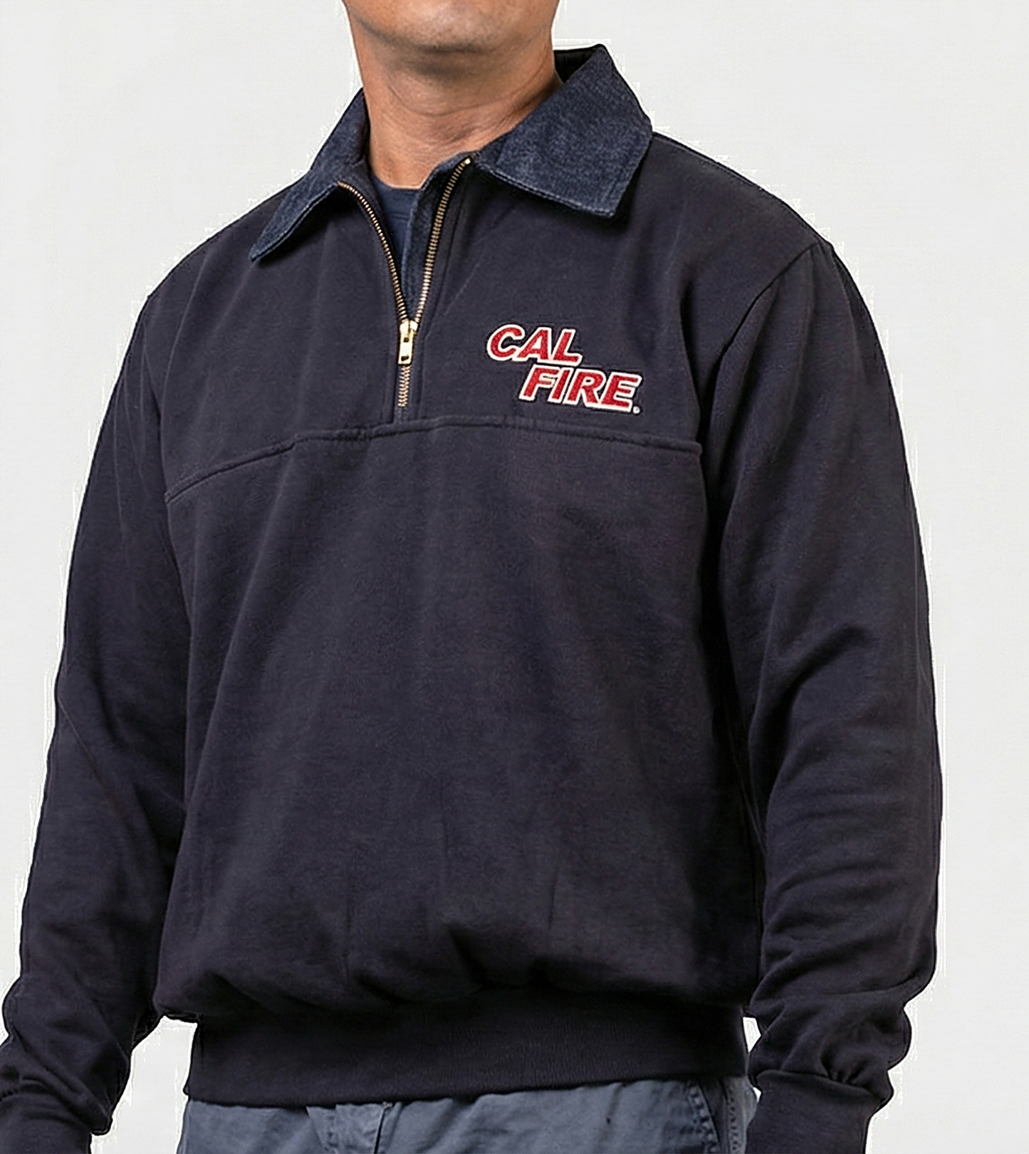 Male model facing forward in the navy job shirt, red CAL FIRE italic wordmark on the left chest below the denim collar.
