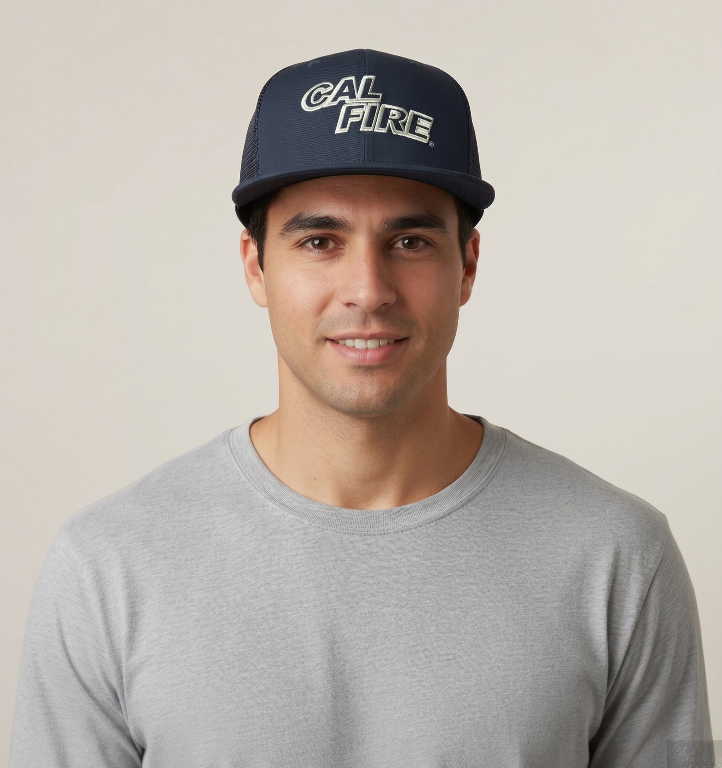 Model front view of a man in a gray long-sleeve tee wearing the navy mesh-back trucker snapback with the white CAL FIRE wordmark on the crown.