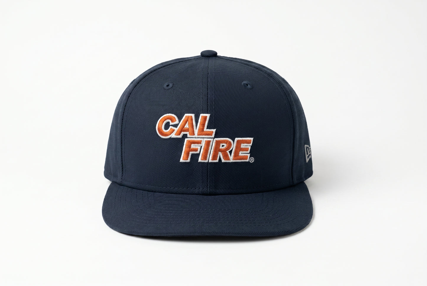 Straight-on front view of the navy snapback showing the orange-red CAL FIRE wordmark centered on the crown and a tonal New Era flag on the side.