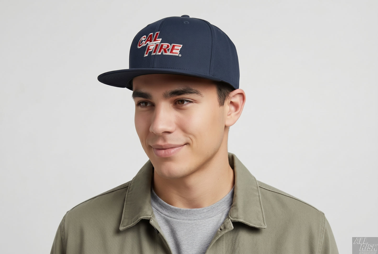 Young man in an olive shirt wearing the midnight navy CAL FIRE New Era 403 snapback with the red wordmark.