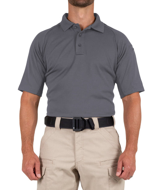 Man wearing a gray polo shirt and beige pants on a white background