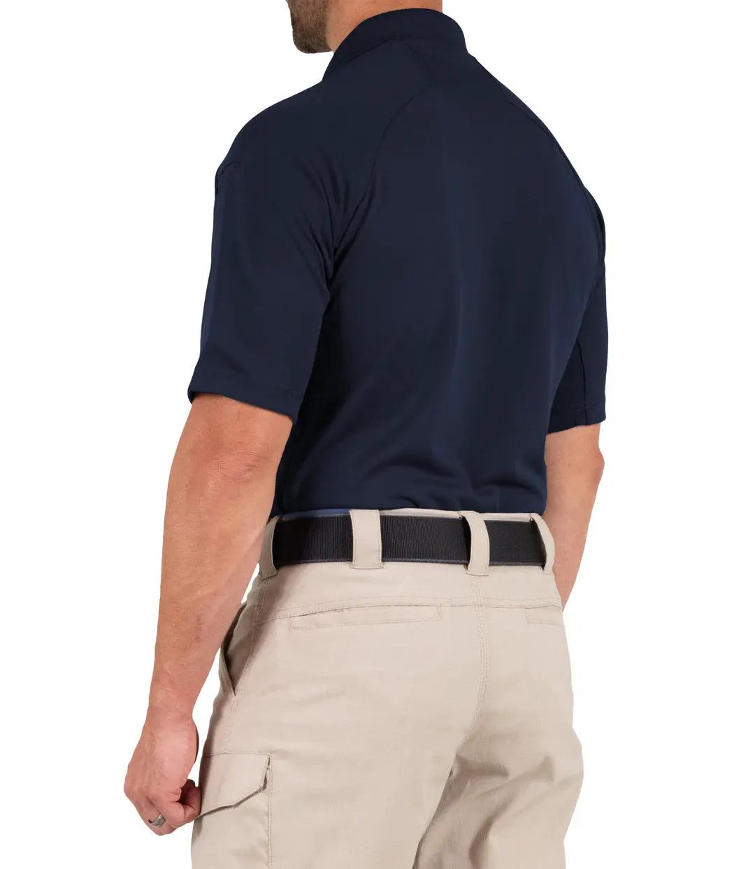 Full back view of a model in the plain navy polo, showing the unprinted back, raglan shoulder seams, and khaki tactical pants.