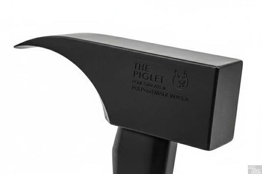 Close-up detail of PIGlet tool head showing 6lb tool steel construction with black oxide finish and striking surfaces