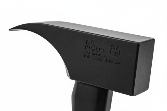 Close-up detail of PIGlet tool head showing 6lb tool steel construction with black oxide finish and striking surfaces