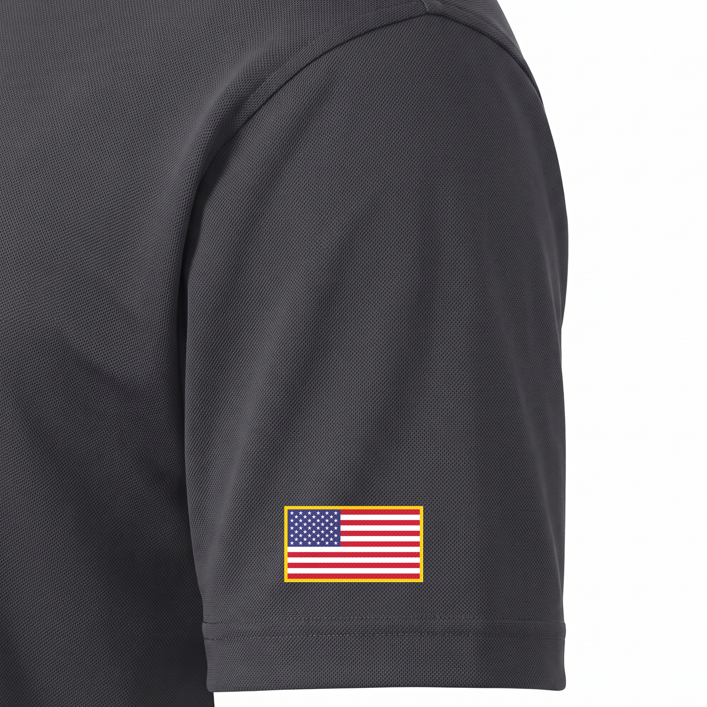Siskiyou Trojans men's Sport-Tek polo in iron grey, close-up of the left sleeve showing the United States flag patch just above the sleeve hem